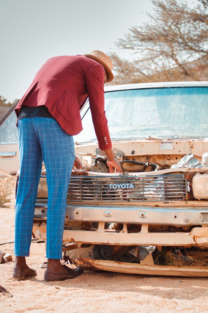 Anonymous trendy man checking engine of broken car